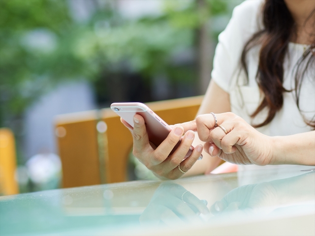 スマホを操作する女性の手