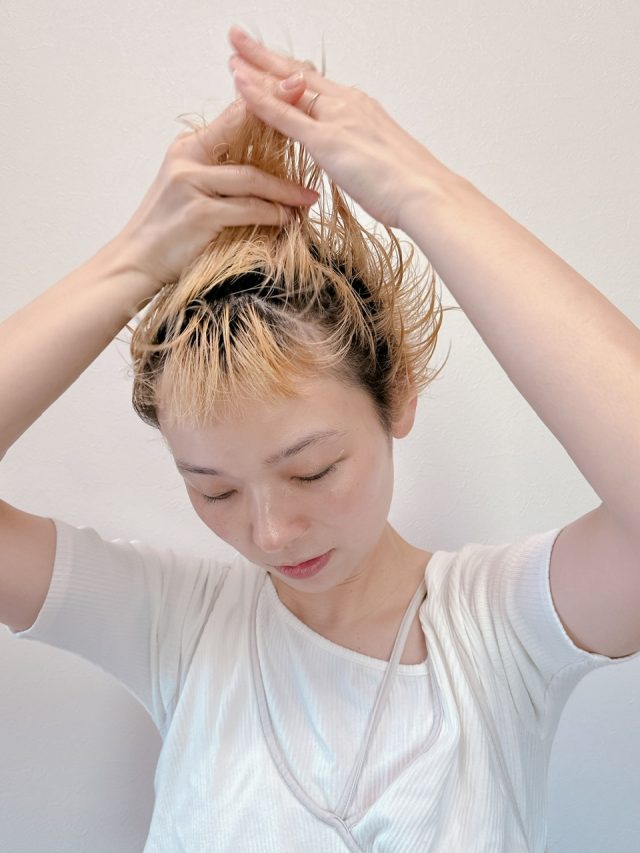 手のひらになじませたスタイリング剤を髪に付ける