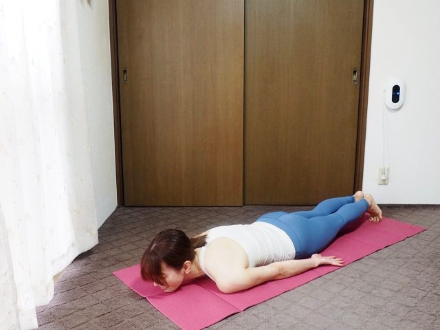うつ伏せで、つま先を立てる女性