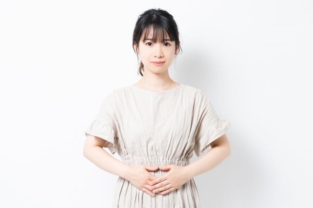 お腹に手を当てる女性