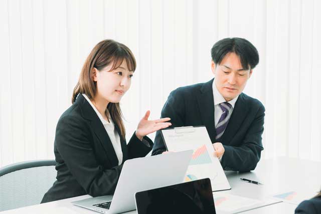会議をしているスーツ姿の女性と男性