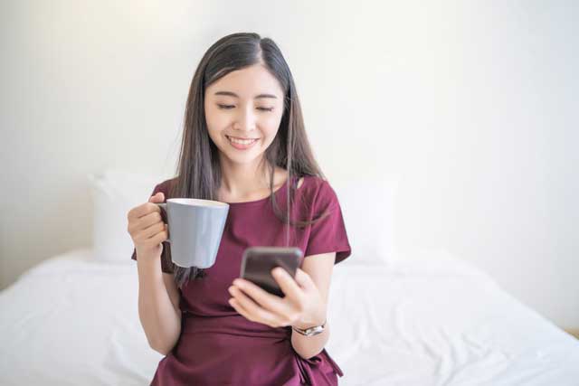 スマホ　マグカップ　コーヒー　朝　女性 