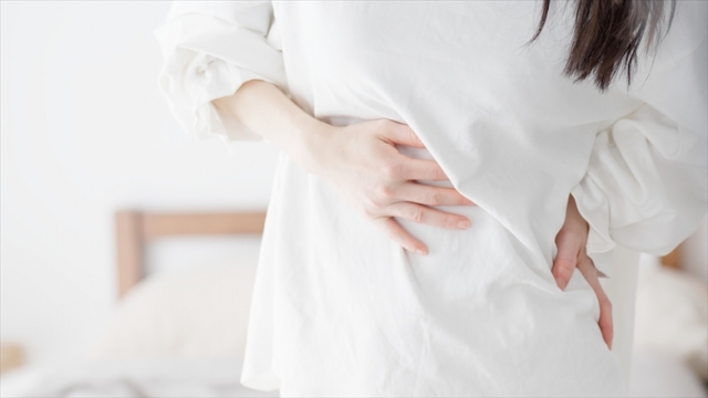お腹に手を当てる女性