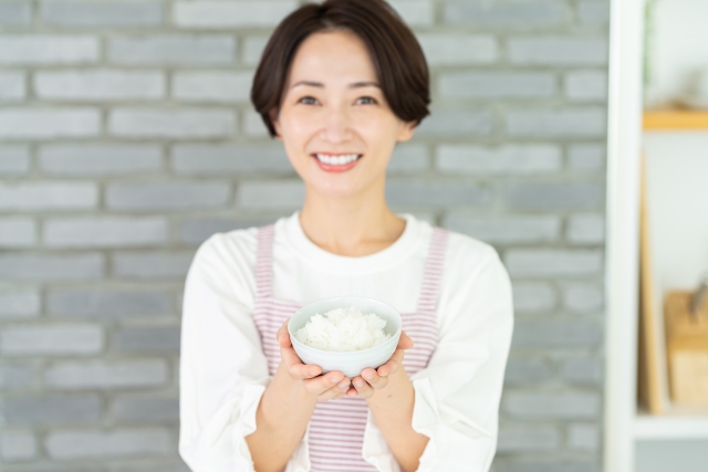 御飯茶碗を持った笑顔の女性