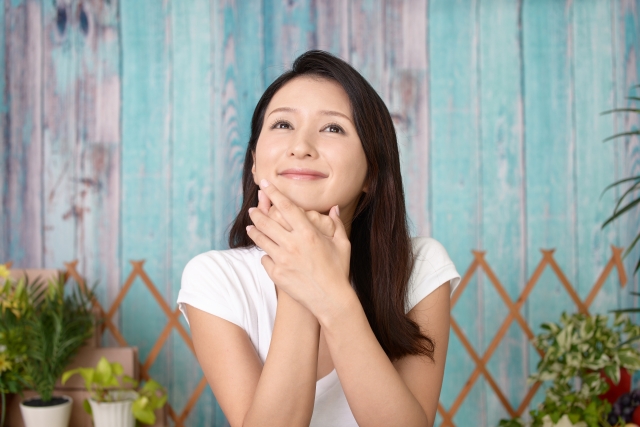 笑顔で考えごとをする女性