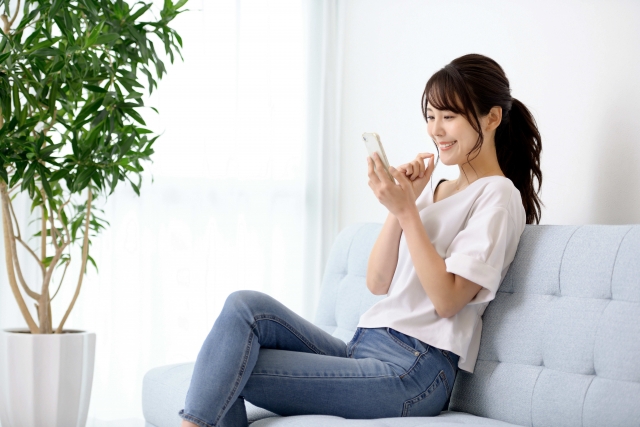 座ってスマホを見る女性