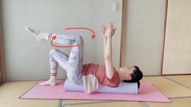 ポールに仰向けになって両腕と片脚を上げ、膝で円を描くように回す動き