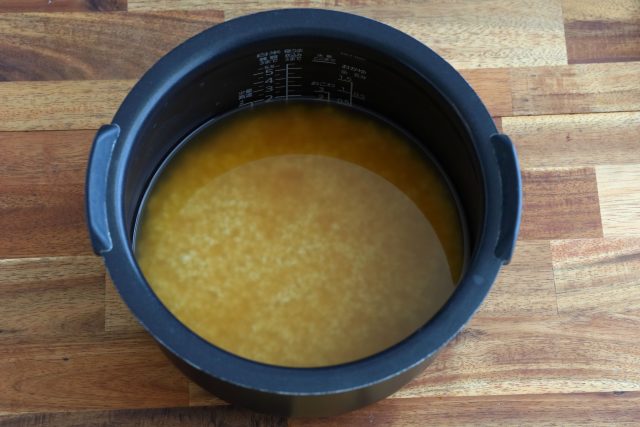 炊飯器に米と調味料、水を加えて混ぜる